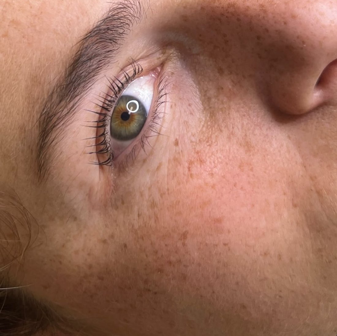 A close-up of an eye with a natural Korean lash lift and tint